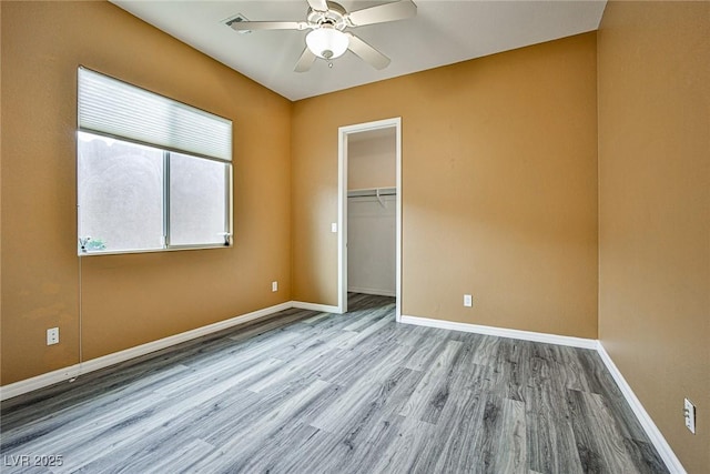 unfurnished bedroom with visible vents, a ceiling fan, wood finished floors, a closet, and baseboards