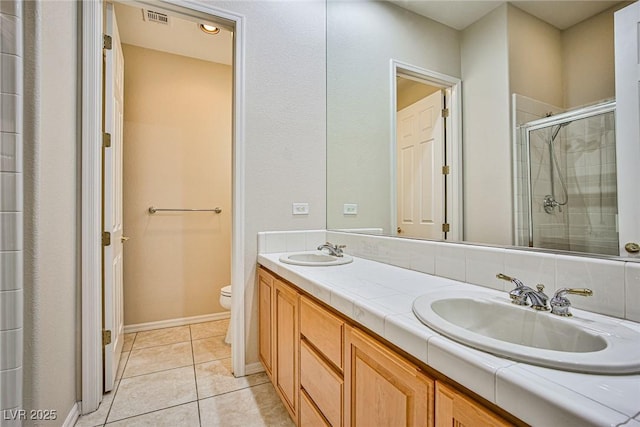 full bathroom with a shower stall, toilet, visible vents, and a sink