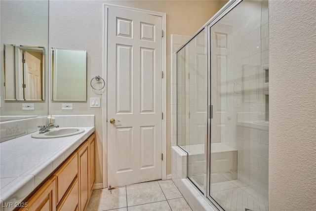 full bath featuring vanity, a shower stall, and tile patterned flooring