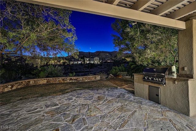 view of patio featuring an outdoor kitchen and a grill