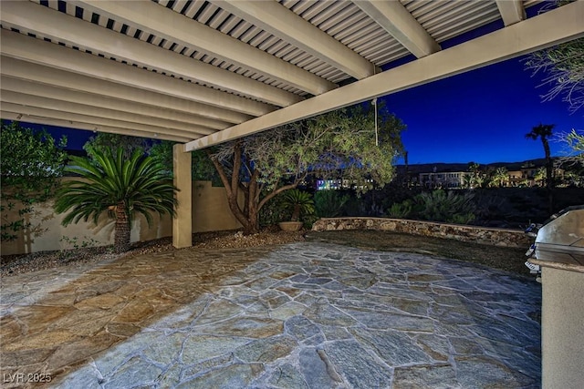 patio at night with a fenced backyard