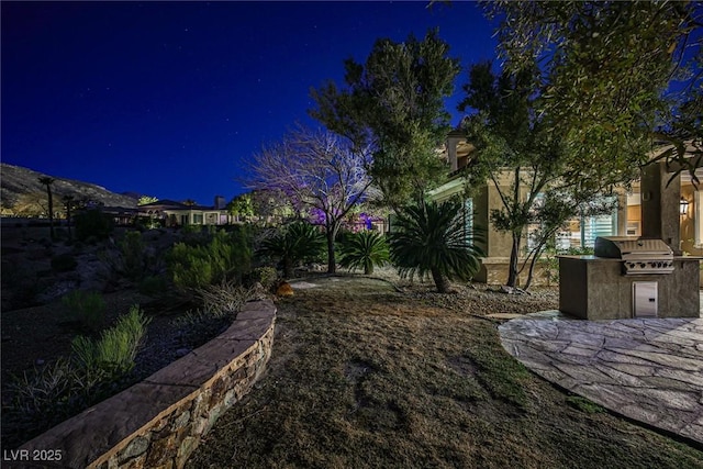 yard at twilight featuring area for grilling