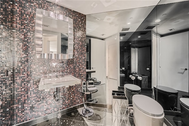 bathroom featuring visible vents, toilet, tile walls, and granite finish floor