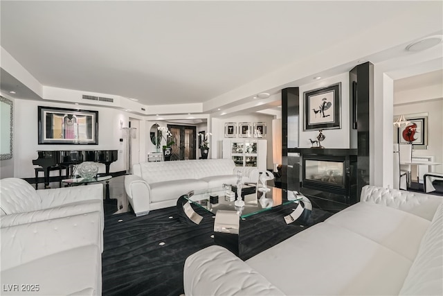 living room featuring a multi sided fireplace and visible vents