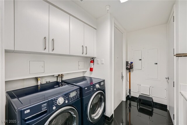 clothes washing area with electric panel, cabinet space, and separate washer and dryer