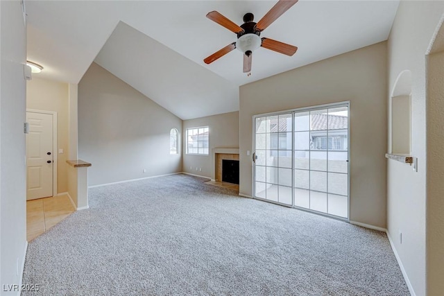 unfurnished living room with baseboards, a fireplace with flush hearth, carpet, and lofted ceiling