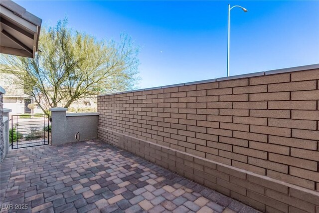 view of patio featuring fence and a gate