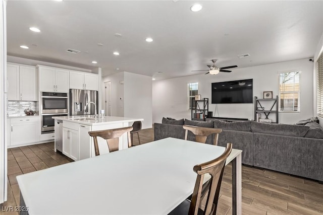 dining room with wood finish floors, visible vents, ceiling fan, and recessed lighting