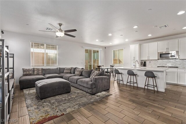 living room with visible vents, plenty of natural light, and wood tiled floor