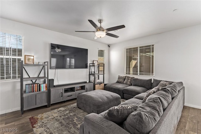 living area featuring wood finished floors, baseboards, and ceiling fan