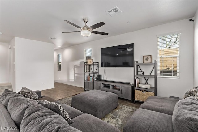 living room featuring visible vents, a ceiling fan, and wood finished floors