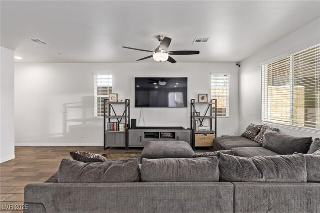 living room with visible vents, a healthy amount of sunlight, and wood finished floors