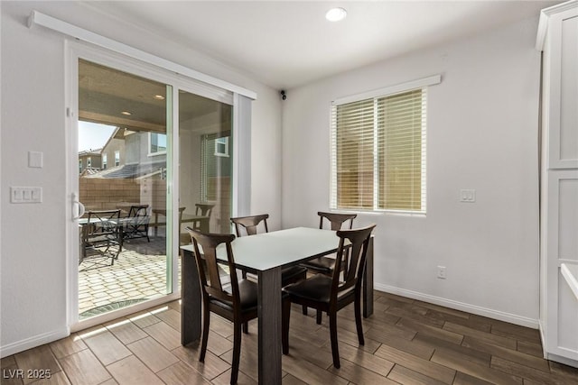 dining area with baseboards and wood tiled floor