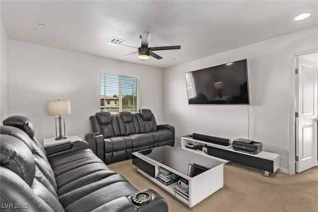 living area with visible vents, light colored carpet, baseboards, and ceiling fan