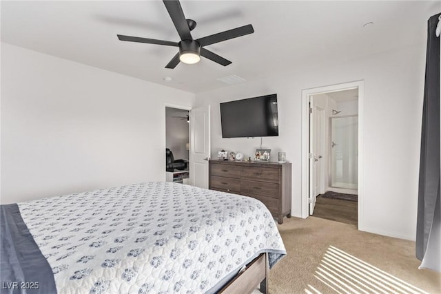 bedroom featuring connected bathroom, baseboards, light colored carpet, and a ceiling fan