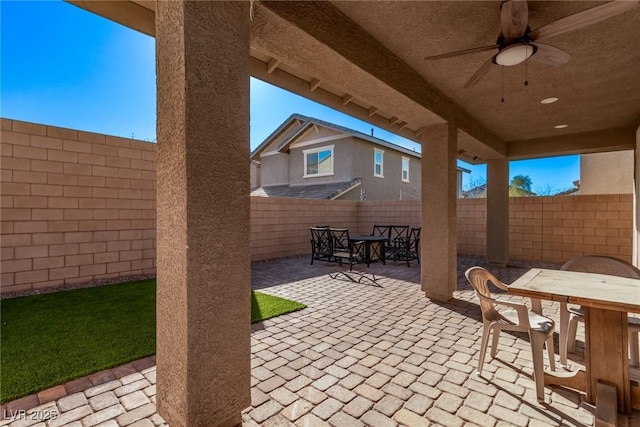 view of patio with a ceiling fan, outdoor dining area, and a fenced backyard