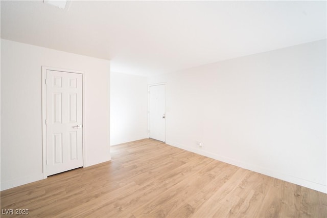 empty room with light wood-style floors and baseboards