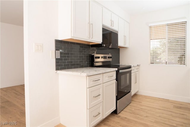 kitchen with baseboards, stainless steel electric range, decorative backsplash, white cabinets, and light wood-style floors