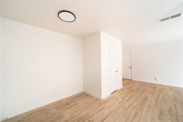 unfurnished room with visible vents, baseboards, and wood finished floors