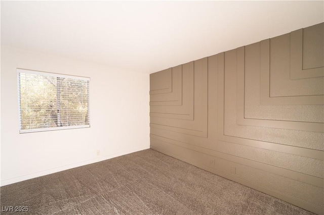 empty room featuring carpet and baseboards