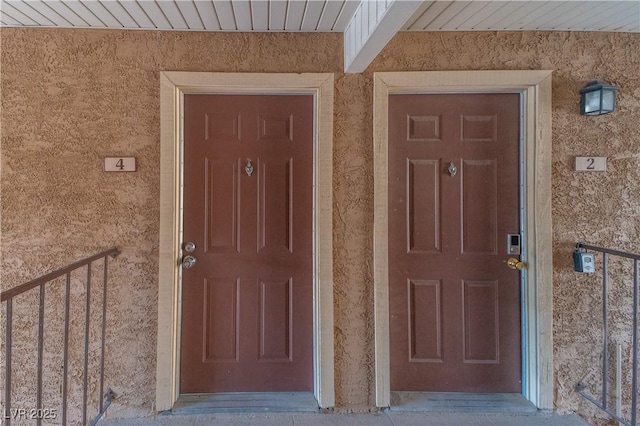 property entrance with stucco siding