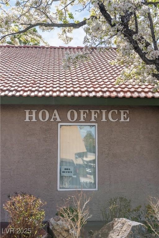 details with stucco siding and a tiled roof