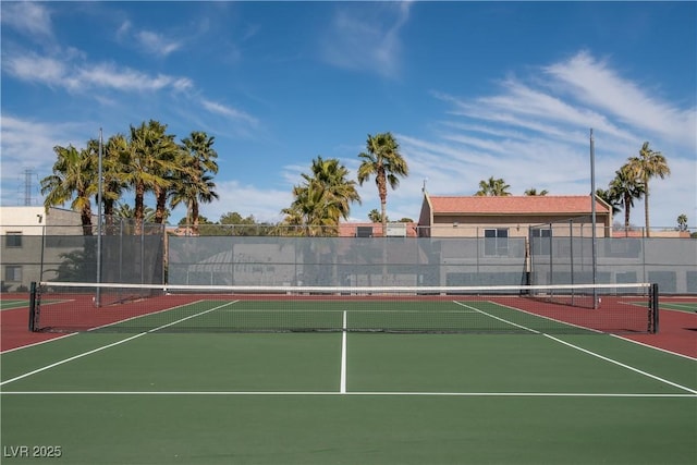 view of tennis court with community basketball court and fence