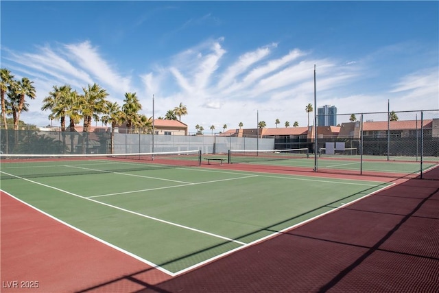 view of tennis court with community basketball court and fence