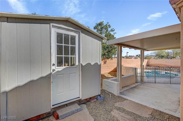 view of outbuilding featuring an outbuilding, fence, and a fenced in pool