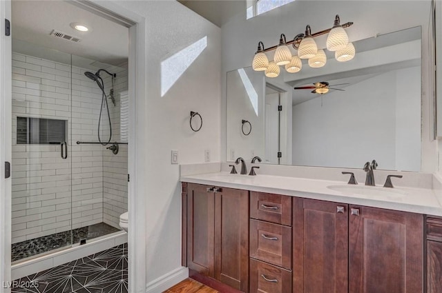 full bath featuring visible vents, a shower stall, toilet, double vanity, and a sink