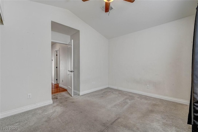 carpeted spare room featuring visible vents, lofted ceiling, baseboards, and a ceiling fan