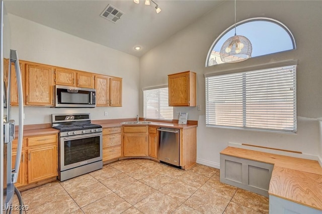 kitchen featuring visible vents, high vaulted ceiling, a sink, stainless steel appliances, and light countertops