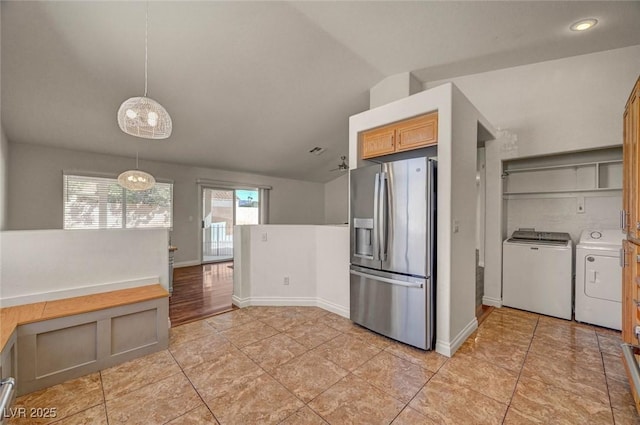 kitchen featuring baseboards, separate washer and dryer, hanging light fixtures, vaulted ceiling, and stainless steel fridge