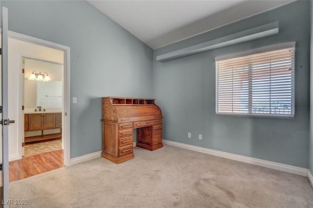 office with baseboards, lofted ceiling, and light colored carpet