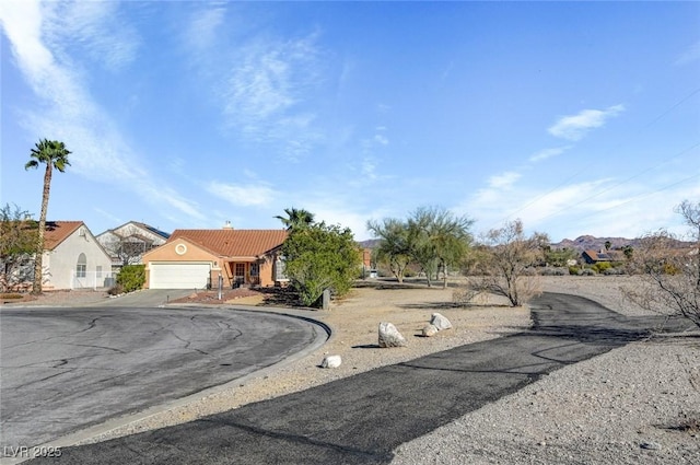 view of front of house with a tiled roof, an attached garage, and driveway