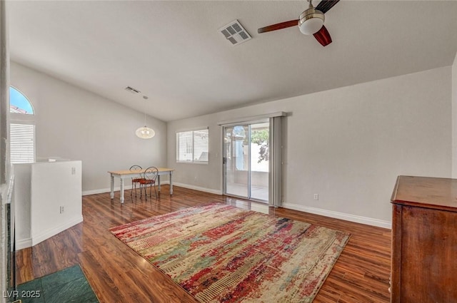 living area with lofted ceiling, wood finished floors, visible vents, and baseboards