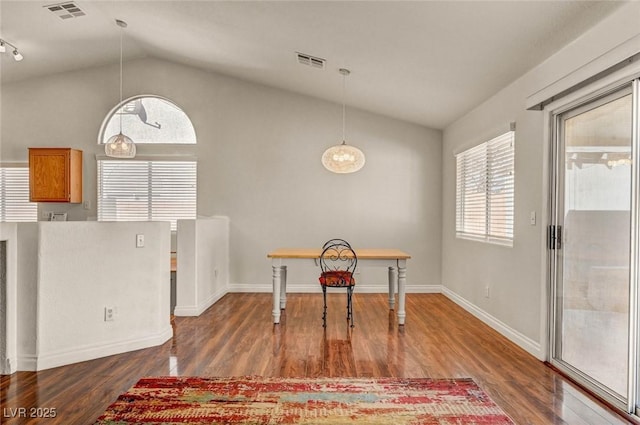 dining area with visible vents, baseboards, lofted ceiling, and wood finished floors