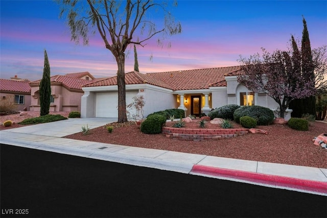 view of front facade featuring a tile roof, stucco siding, an attached garage, and concrete driveway