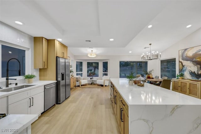 kitchen featuring lofted ceiling, recessed lighting, a sink, stainless steel appliances, and light wood-style floors