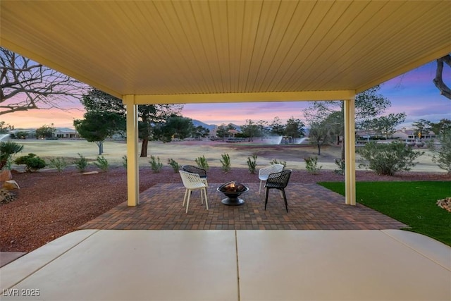 patio terrace at dusk featuring an outdoor fire pit