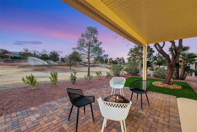 patio terrace at dusk featuring a fire pit