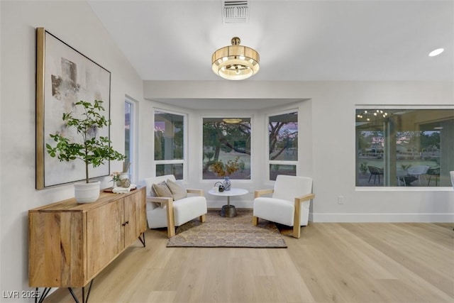 living area with visible vents, recessed lighting, light wood-type flooring, and baseboards