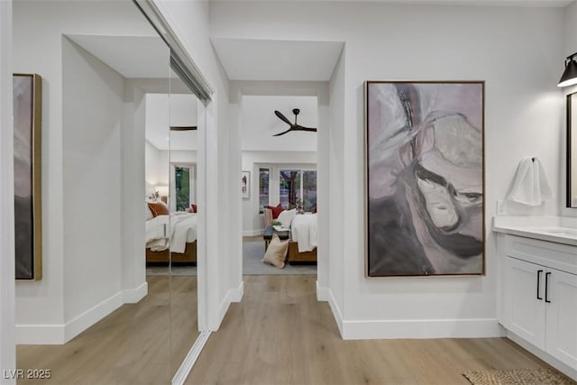 hall featuring baseboards and light wood-style flooring