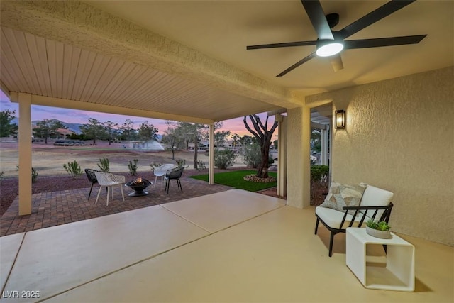 patio terrace at dusk featuring a ceiling fan