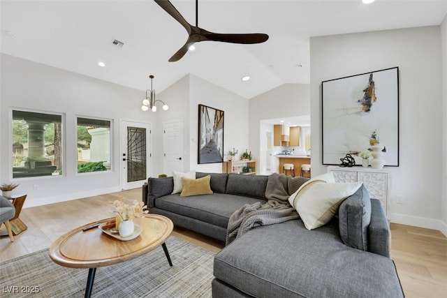 living room with recessed lighting, baseboards, lofted ceiling, and light wood-style flooring