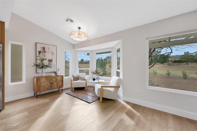 sitting room featuring visible vents, lofted ceiling, baseboards, and light wood finished floors