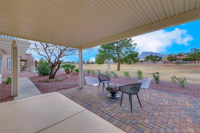 view of patio / terrace with a mountain view and a fire pit