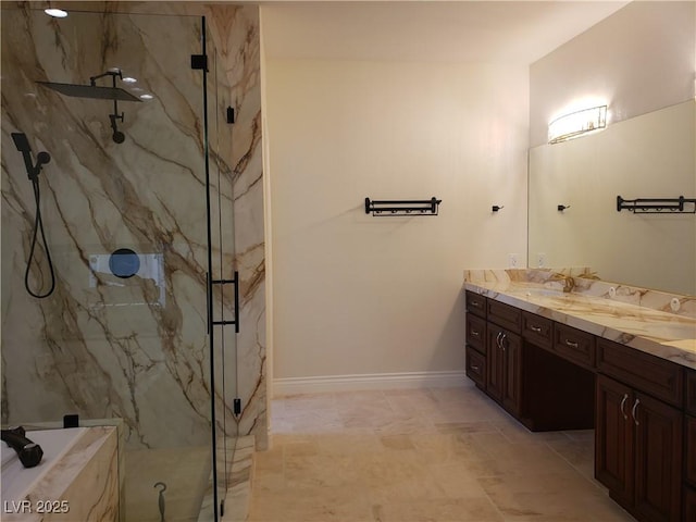 full bathroom featuring a sink, a marble finish shower, baseboards, and double vanity