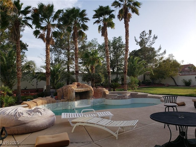 view of pool featuring a patio area, a pool with connected hot tub, and fence