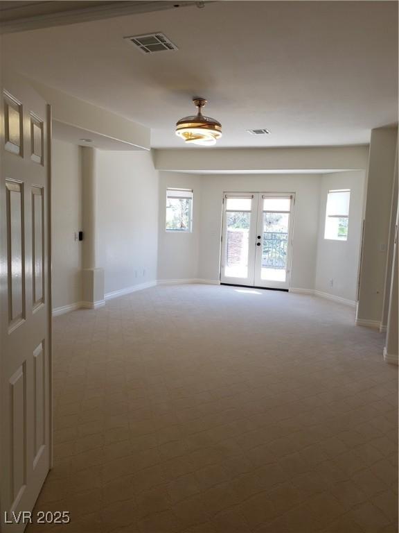 spare room featuring french doors, visible vents, and baseboards